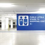 A digital printed wall graphic used as directional signage in a car park
