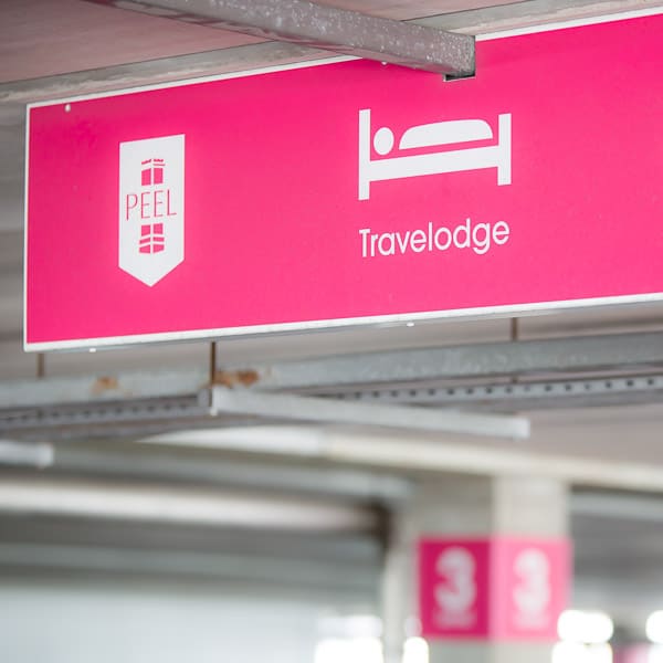 A suspended directional sign in a car park