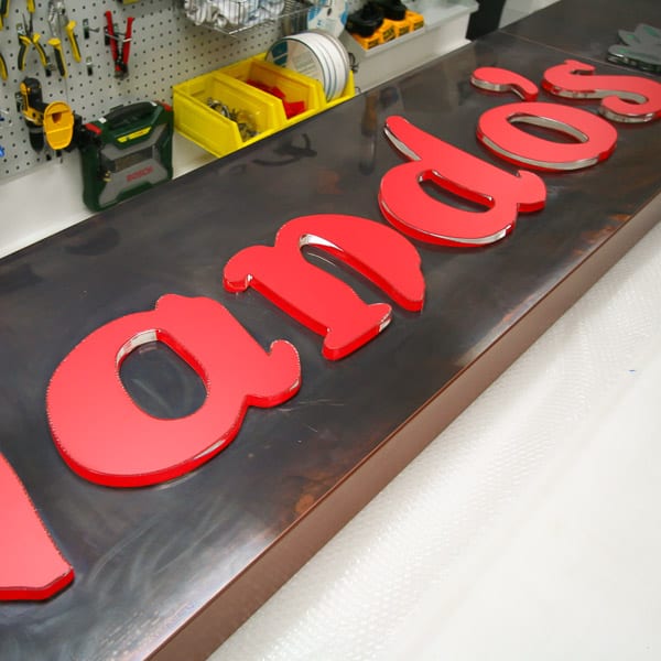 Nandos Restaurant sign being fabricated in our workshop. Made with an aged copper face with acrylic letters pushed through.