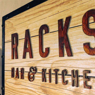 Restaurant signage utilising natural materials along with artificially aged materials