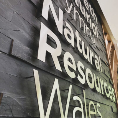 Metal letters mounted to a slate wall on stand off locators