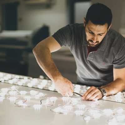 Voodoo employee preparing an LED light tray to install into a shop front sign